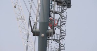 Mobil kuleler soluk endüstriyel gökyüzünün altında yüksekte duruyor. Metal çerçeveler sessiz gün ışığında ışıldıyor ama hâlâ bir amacı var. Sanayi düzeyi