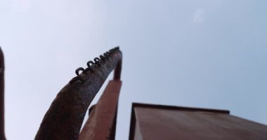 Yıpranmış zincir paslı metal korkuluklara asılır. Kargo gemisi mavi gökyüzünün altında birbirine yakın çekim yapıyor. Bozulmuş tanker yapısı