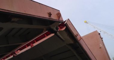 Denizci limanındaki kargo konteynırlarının bulunduğu geminin metal kapısı açılıyor. Büyük toplu taşıyıcı sanayi rıhtımında boşaltmaya hazırlanıyor