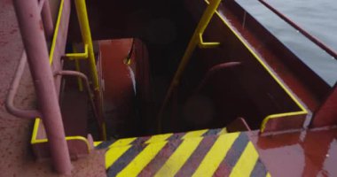 Metal merdiven su basmış ambara iniyor. Damlayan suyun yankıları sessiz deniz karanlığını doldurur. Paslı basamaklar su altındaki odaya açılıyor.