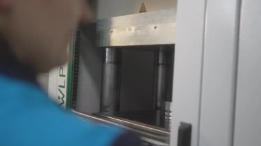 Sarı çerçeveli koruyucu kapı endüstriyel kalıp makinesinde kapanıyor. Güvenlik sistemi, kontrollü ve güvenli materyal işlemini sağlar