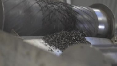 Kaliteli plastik granüller taşıyıcı banttan metal paraşüte düşer. Endüstriyel geri dönüşüm süreci sürekli madde akışını ve sıralamayı gösteriyor