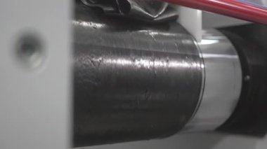 Adam, yüzeyi düzleştirmek için buruşuk lastiği dönen silgiye yerleştirir. Endüstriyel süreç daha ileri işlemler için malzeme arıtma gösteriyor