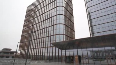 Otel kuleleri, konukseverlik ve şehir altyapısı arasındaki köprünün yanına kurulmuş. Bulutlu hava keskin hatları yumuşatıyor