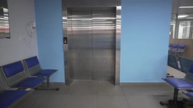 Parlak asansör kapıları yenilenmiş mavi resepsiyon iç kısımları derinlik ve görsel kontrast ekliyor. Uzay profesyonelce hissettiriyor