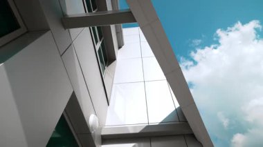 Geometrik yapı köşesi destek kirişini ve beyaz panelleri gösteriyor. Ayrıntılar dikey kule ve panel geometrisini gösteren güçlü çizgiler oluşturur