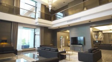 Büyük iki katlı salon kristal avizeler ve sıcak aydınlatmalarla parıldıyor. Simetrik olarak yerleştirilmiş koltuklar zarif iç ölçeğe vurgu yapar