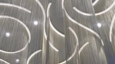 Tavan tasarımı, akan LED lambaları asma detaylarıyla birleştirir. Yaratıcı ışıklandırma düzenlemesi sofistike atmosfer ekler