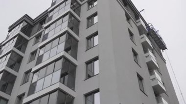 Katı cepheli yüksek binalar konut kompleksi ve ofis merkezini birleştirir. Monolitik gri kule modern şehir yaşam tarzını yansıtıyor