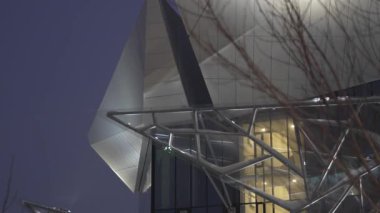 Tiyatronun ön cephesinin mimari parçası hafif taş kiremitlerle kaplı. Akşam aydınlatması doku geometrisi ve yapısını vurguluyor