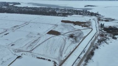 Kış manzarası teknik alanı kar katmanıyla kaplar. Kasvetli hava sert sanayi ortamını güçlendiriyor.