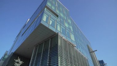 Yansıtıcı yapı yüzeyi parlak atmosferik arka planda çözünür. Temiz geometri asgari modern tasarımı vurgular. Havai mimari