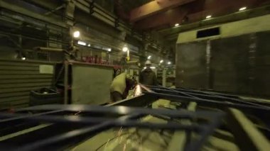 ALMATY, KAZAKHSTAN - 18 Eylül 2025: Makinelerle dolu kalabalık atölyeyi hızla geçiyor. Görsel akış, endüstriyel üretim POV 'unun ölçeği ve organizasyonunu vurguluyor