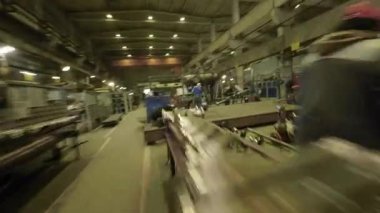 ALMATY, KAZAKHSTAN - 18 Eylül 2025: İşçiler ekipman dolu atölyede üretim görevlerini çözen gruplar halinde işbirliği yapıyorlar. Koordineli aktivite takım çalışması ve disiplini yansıtır