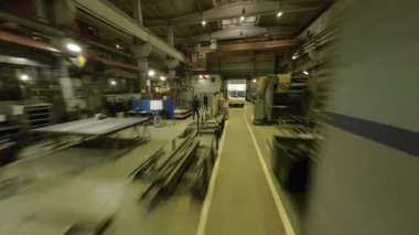 ALMATY, KAZAKHSTAN - 18 Eylül 2025: Çalışan atölye katındaki hareketlilik insanların ve makinelerin çalışmalarını ön plana çıkarıyor. Olay yeri, endüstriyel üretim çevresi POV 'nin güvenilirliğini aktarıyor