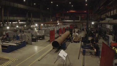 ALMATY, KAZAKHSTAN - 18 Eylül 2025: Dev çelik boru kaynaklama faaliyetleri ve ayrıntılı görevler yapan işçilerle dolu yoğun bir atölye. Koordinasyonla birlikte ritim