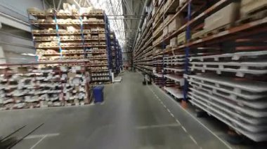 ALMATY, KAZAKHSTAN - 18 Eylül 2025: Malzeme ve ürünlerle dolu uzun raflar arasında kamera hareketi. Geniş iç taşımacılık organize üretim ortamı POV