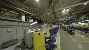 ALMATY, KAZAKHSTAN - 18 Ocak 2025: İşçiler kişisel bölgelerdeki görevleri yönetirken makineler arasında aktif olarak hareket ederler. Sürekli hareket dinamik endüstriyel ritim yaratır.