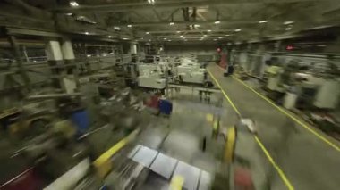 ALMATY, KAZAKHSTAN - 18 Ocak 2025: İHA perspektifi makine ve hareket personeliyle dolu endüstriyel atölyeyi ortaya çıkardı. Gelişmiş teknoloji hareketli POV sahnesine hakim.