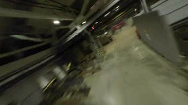 ALMATY, KAZAKHSTAN - 18 HAZİRAN 2025: Havadan insansız hava uçakları makine ve çalışan personelle dolu bir atölye katından geçiyor. Sürekli endüstriyel üretim POV enerjisi