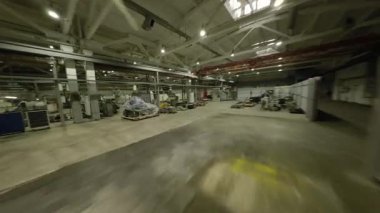 ALMATY, KAZAKHSTAN - 18 HAZİRAN 2025 İHA uçuşu aktif personelle birlikte makinelerle dolu atölyeyi ortaya çıkardı. Teknolojik karmaşıklık ve senkronize aktivite POV