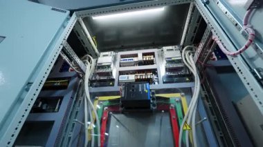 Elektriksel kontrol paneli, düzenlenmiş şalterlerle ve otomasyon cihazlarıyla dolu. Kablolar ve anahtarlar kesin bir düzen gösteriyor