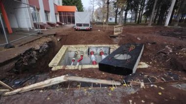 Kazılmış siper, yerin altında karmaşık elektrik boru hatları şebekesini ortaya çıkarıyor. İnşaat alanı kentsel yenileme sürecini gösteriyor