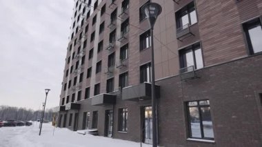 Kahverengi cepheli ve sayısız pencereli çok katlı bina yoğun ritmik dış şebekeler oluşturuyor. Mimarlık katı tekrarlanan şehir hissi veriyor.