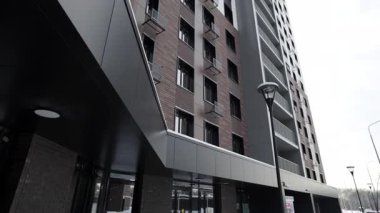 Şık siyah gölgelik ve cam kapılarla çerçevelenmiş konut kompleksine giriş. Tasarım zarafeti modern rahatlıkla iletir.