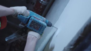 ALMATY, KAZAKHSTAN - 19 Eylül 2025: İşçi matkapları duvarı derin bir şekilde açıyor ve toz oluşturuyor. Sahne, ham inşaat enerjisi ve mekanik kuvveti iletir