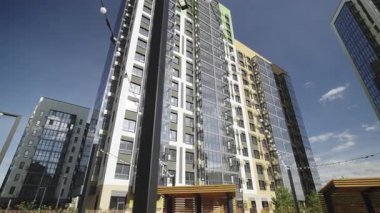 Sokak çelenkleri mavi gökyüzüne yükselen konut binasının avlusuna kadar uzanıyor. Dekoratif ışıklandırma havadar kentsel bileşim oluşturur