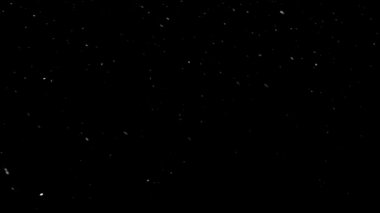  Noel 'de beyaz kar taneleri siyah arka planda farklı şekillerde uçar.