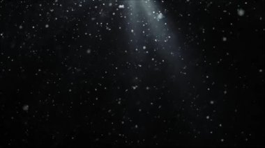 Işık saçan ışınların arka planına kar taneleri düşüyor. Noel süslemesi