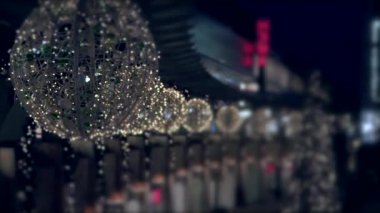 Gece vakti şehrin sokaklarında karanlıkta parlayan noel ışıkları. Soyut renkli bokeh ile şehir gecesinin görüntüsü 