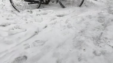 Terk edilmiş bisikletler karla kaplı ve buzla kaplı, sokak lambasında duruyor. Kışın zor hava koşulları bisiklet sürmeyi imkansız kılıyor. Şiddetli kar yağışıweather condition