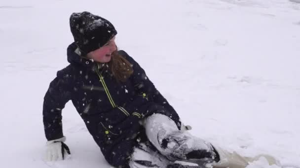 幸せな女の子のふわふわの雪の中で 光のふわふわのフレークを飛び回る 涼しい風 雪の結晶と楽しい女の子の遊び 冬のパーで自分自身を楽しませる — ストック動画