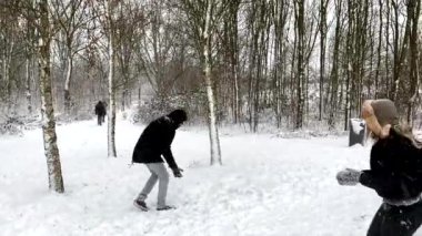 Mutlu aile kış parkında karla oynarken eğleniyor. 4K çözünürlüğü