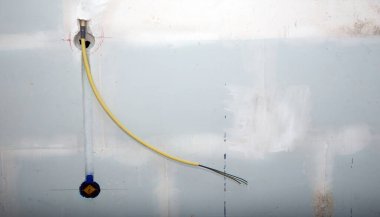 Eski beton bir duvara prizler için gizli elektrik kabloları kurulumu