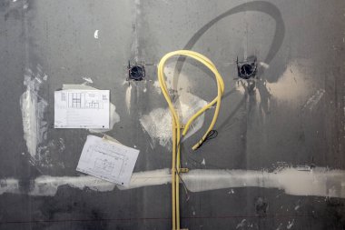 Beton bir duvarın içine gizlenmiş elektrik kabloları. Eski bir dairede onarım ve prizlerin transferi