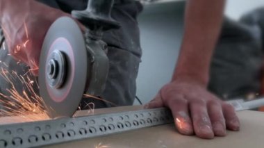 Tamirat sırasında metal profili öğütücüyle kesmek. Bir sürü sürtünme kıvılcımı