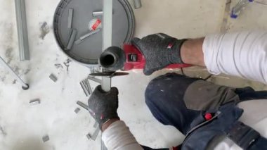 Metal profili kesen profesyonel inşaat işçisi. Tamirat sırasında metal profili öğütücüyle kesmek. Bir sürü sürtünme kıvılcımı