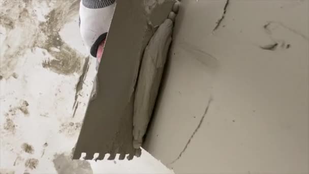 Tiler Εφαρμόζει Κόλλα Στο Πάτωμα Για Την Εγκατάσταση Κεραμικών Πλακιδίων — Αρχείο Βίντεο