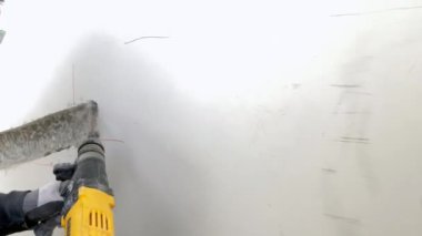 İnşaatçı inşaat alanında beton kırıyor.