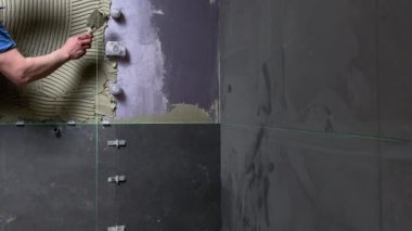 Tiler seramik fayansları yerleştirmek için yere yapıştırıcı sürüyor. İnşaat alanında fayans döşemek