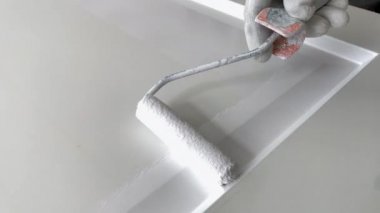 Boyacı kapanışı. İşyerindeki ressam ahşap kapıyı beyaz boyayla boyuyor.