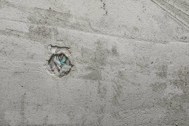 Beton bir duvarda elektrik kablosu ve bağlantı kutusu açılmış. Eski bir dairede tadilat ve çorap nakli. İnşaat alanında elektrik işleri