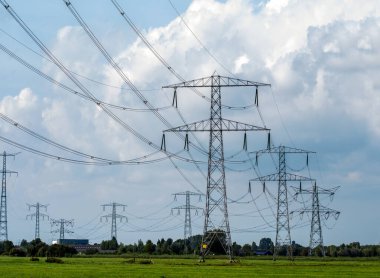 Yüksek voltajlı elektrik hatları. Gökyüzü ve bulutların arka planında elektrik direkleri.