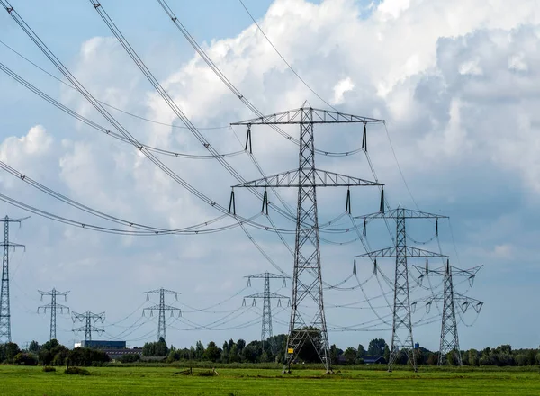Yüksek voltajlı elektrik hatları. Gökyüzü ve bulutların arka planında elektrik direkleri.