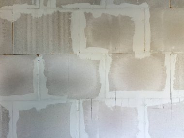 Tamamlanmamış AAC blok duvarının, yeni eklem bileşimi ve dikişleri ile yakın çekimleri, iç yenileme sırasında inşaat dokusunu gösteriyor