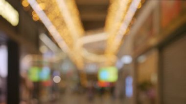 Blurred crowd of people shopping at a mall before Christmas on Black Friday with festive bokeh lights and warm holiday atmosphere 